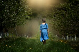 Kind läuft einen sonnigen Waldweg entlang – Symbolbild für Heilung, Entwicklung und das innere Kind